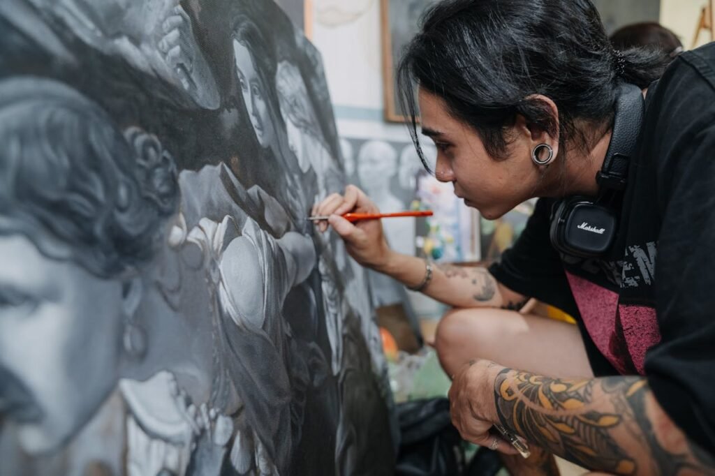 A focused artist skillfully details a black and white painting, showcasing intricate techniques.